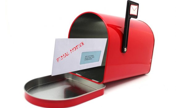 Czerwona skrzynka na listy a w środku list w kopercie z napisem "Final Notice"