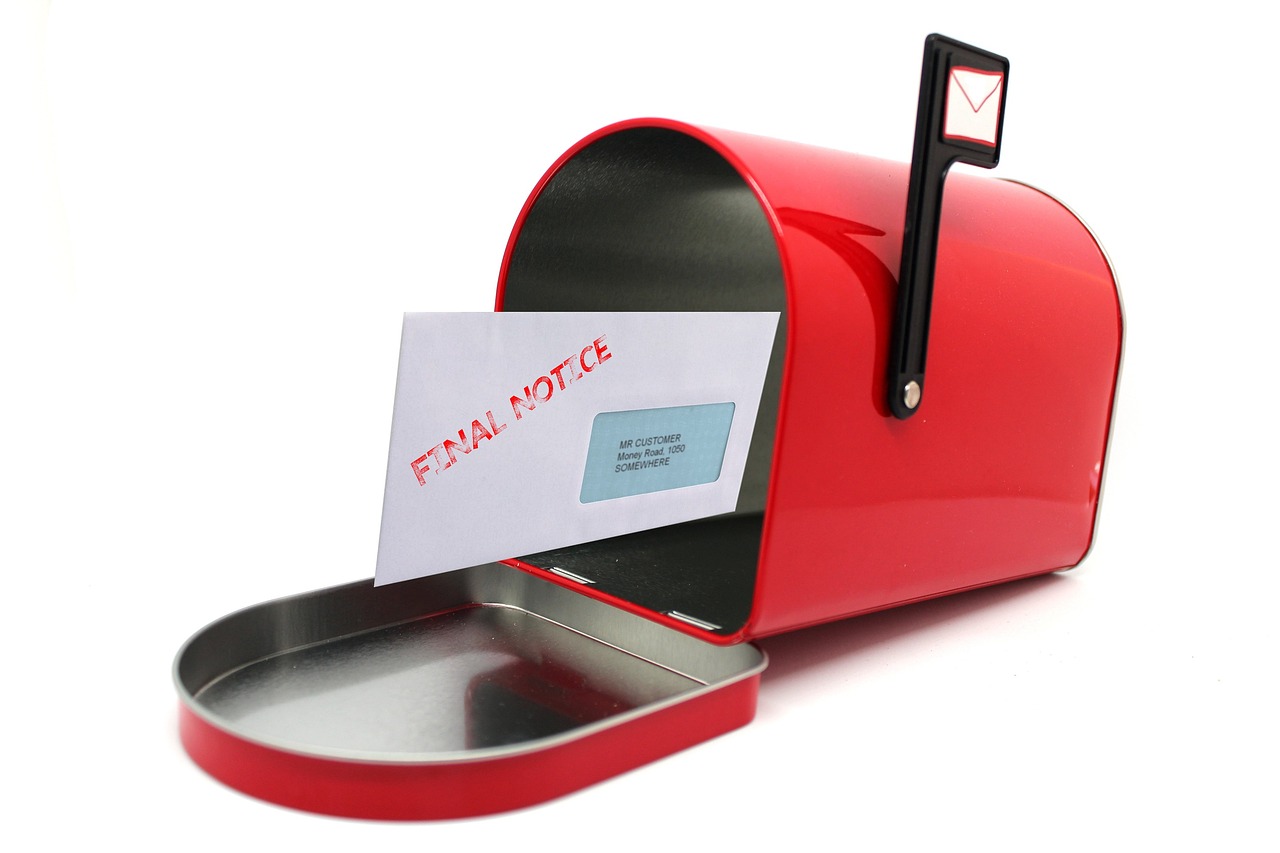 Czerwona skrzynka na listy a w środku list w kopercie z napisem "Final Notice"