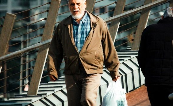 Starszy człowiek idący z wielką torbą na zakupy